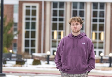Commuter student Jackson Reece poses for a photo in front of the library. 