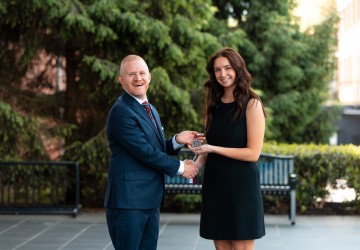 President Quentin Young presents an award to the 2026 presidential scholar.
