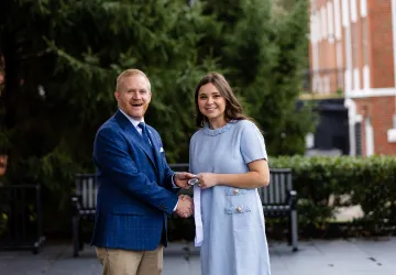 President Young presents a leadership award to student Isabella Watson.