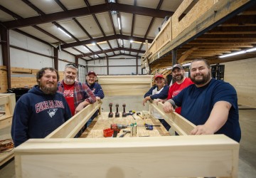 A group of Cumberlands staff members show off a bed they constructed during a service day event.