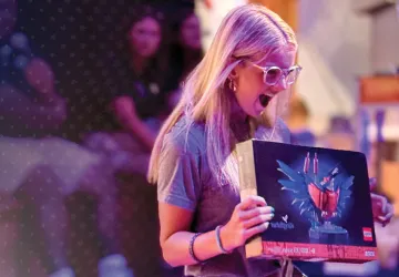 A female holds a Lego set she won during a college orientation event. 