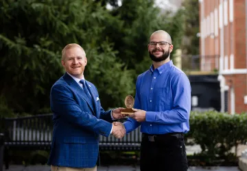 President Young presents a spiritual value award to student Jacob West.