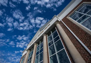 A view of a cloudy sky above the Rollins Family Learning Center. 
