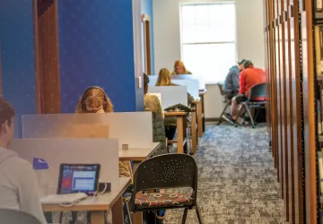 Students sit a kiosks in the library and study. 