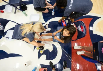 A college volunteer washes the feet of a local student prior to giving her a new pair of shoes during the annual Shoes 4 the Soul event. 