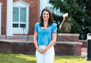 Student Ana Muse poses for a photo in front of the Luecker Building. 