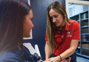 A healthcare student takes the blood pressure of a patient. 