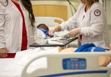 Two nursing students prepare to conduct a clinical examination. 