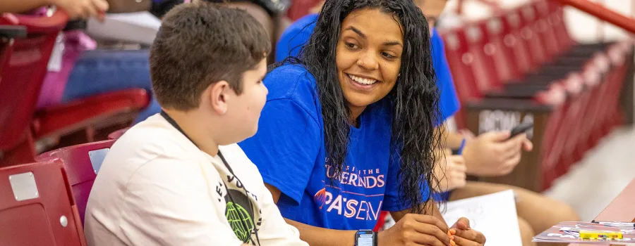 College student speaking with a child
