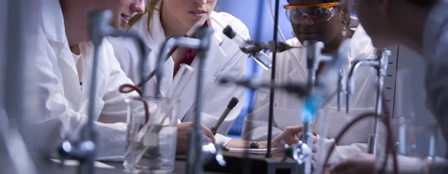 Students perform chemistry experiments in a lab.