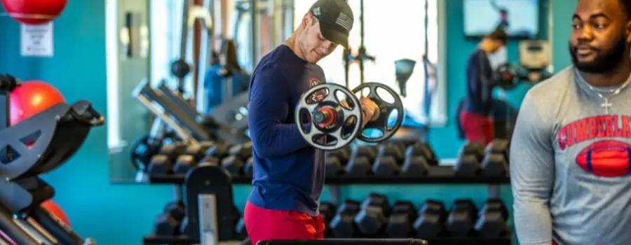 Young man lifting weights in a gym