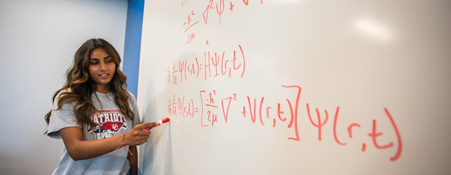 Student explains math equation on whiteboard