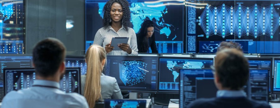 woman surrounded by computers and people