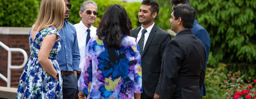 Executive students and professors talking together