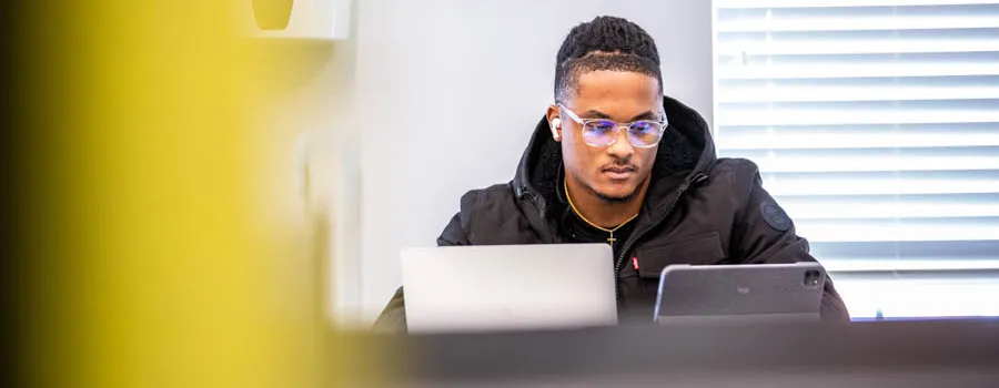 A student using a laptop indoors. 