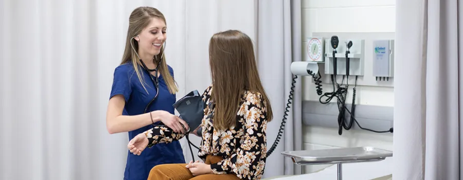 woman checks a patient's blood pressure