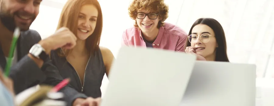 A group of people looking at a laptop