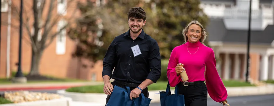 Two students prepare to join leaders at the annual business forum