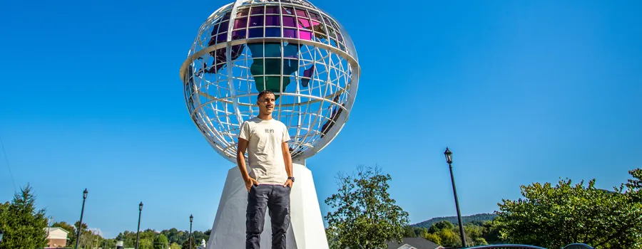 A Cumberlands student stands near the globe on campus