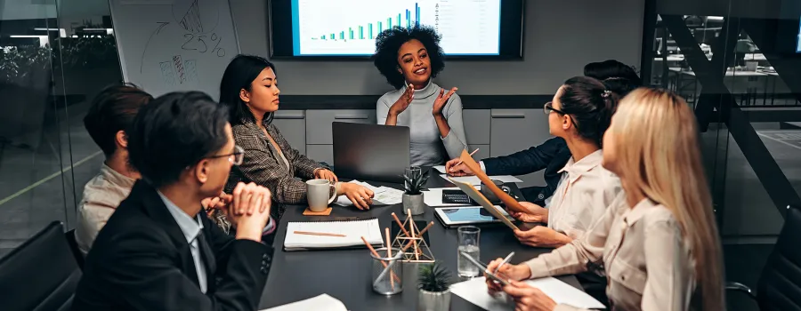 A team of business professionals discuss a plan during a meeting. 
