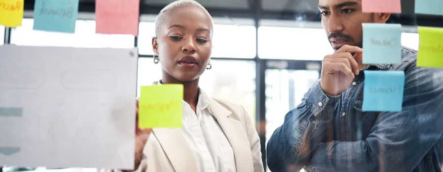 Two professionals work discuss marketing notes.