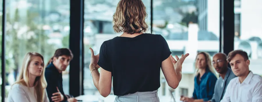 A business woman leads her team in a meeting.