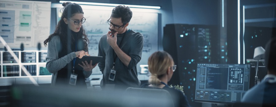 A woman and man look at a computer inside an office studying machine learning. 