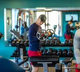 Young man lifting weights in a gym
