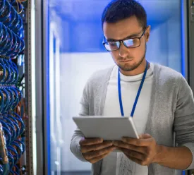 man in computer room looking at iPad