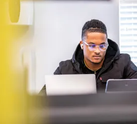A student using a laptop indoors. 