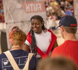 Young woman greeting students at a campus event