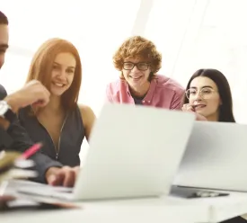 A group of people looking at a laptop