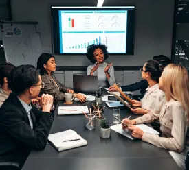 A team of business professionals discuss a plan during a meeting. 