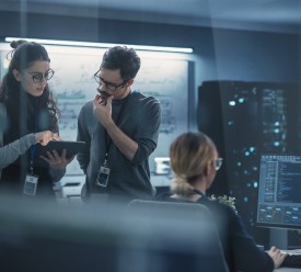 A woman and man look at a computer inside an office studying machine learning. 