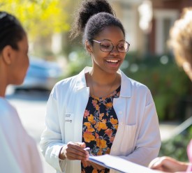 A female health worker is getting other women to complete a survey.