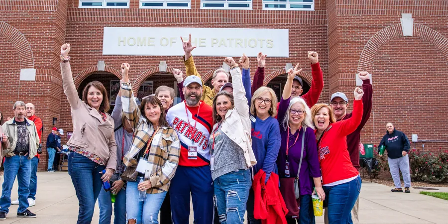 A group of alumni celebrate prior to the Homecoming football game 