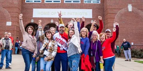 A group of alumni celebrate prior to the Homecoming football game 