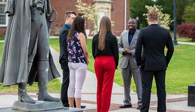 Several people standing outside having a conversation
