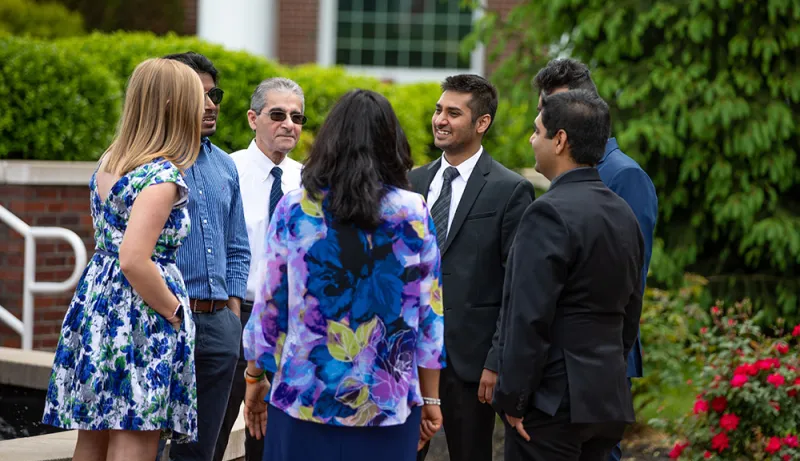 Executive students and professors talking together