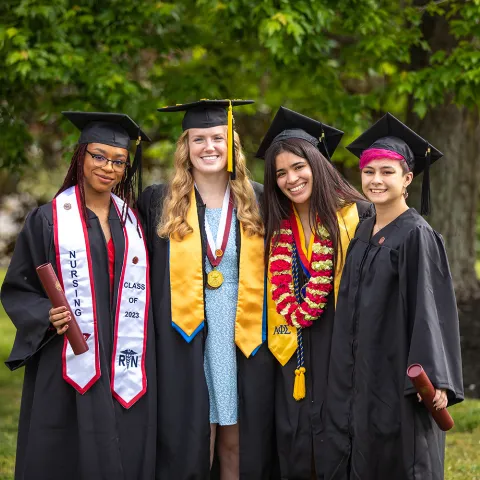 Four wrestlers pose after graduation