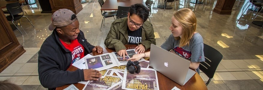 Journalism degree students reviewing pictures for a University of the Cumberlands news article.