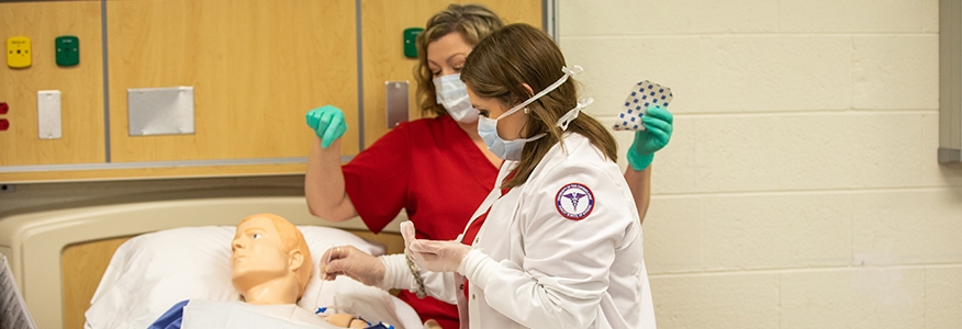 A nursing student practices an examination in class 