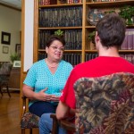 A woman speaking with a young man