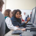 Two students working on a computer together