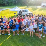A group of people standing in a field posing for a picture