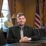 A young adult seated at a conference table