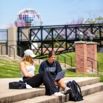 Two students seated on steps outside