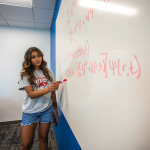 A student working on physics in the library. 