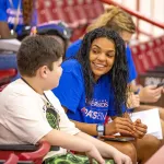 College student speaking with a child