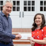 Two people holding an envelope 